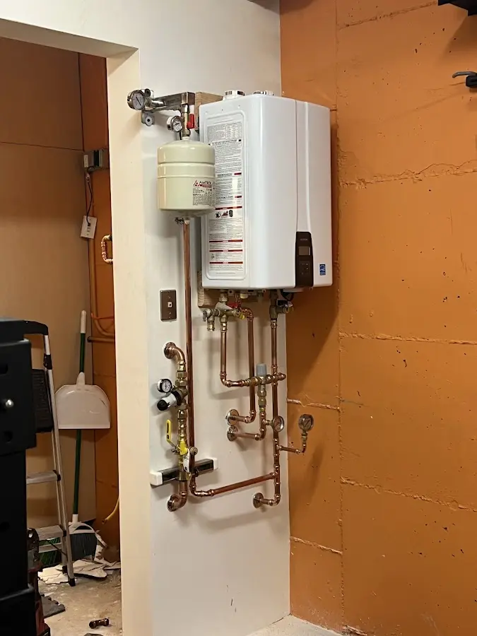 Plumbing technician inspecting water heater connections in North Oaks